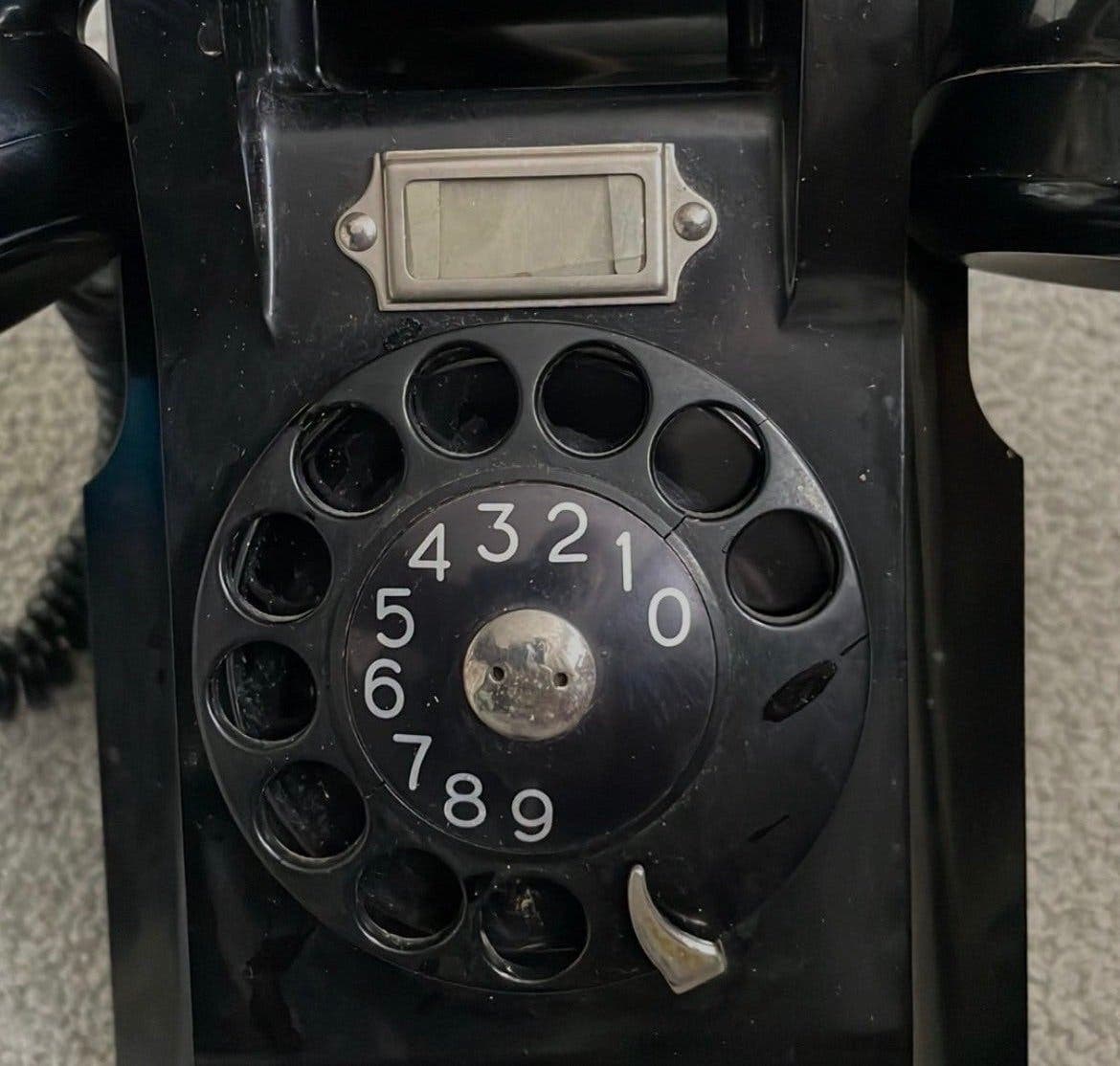 Äldre Ericsson väggtelefon -telefon med fingerskiva, svart