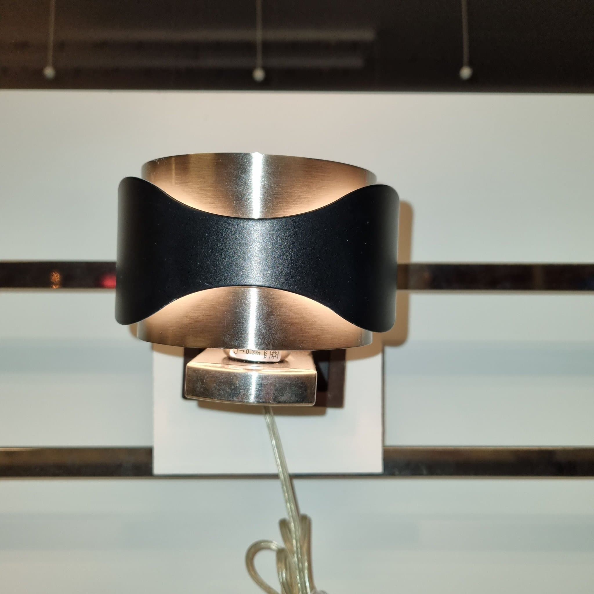 Vägglampa i svart och borstad metall